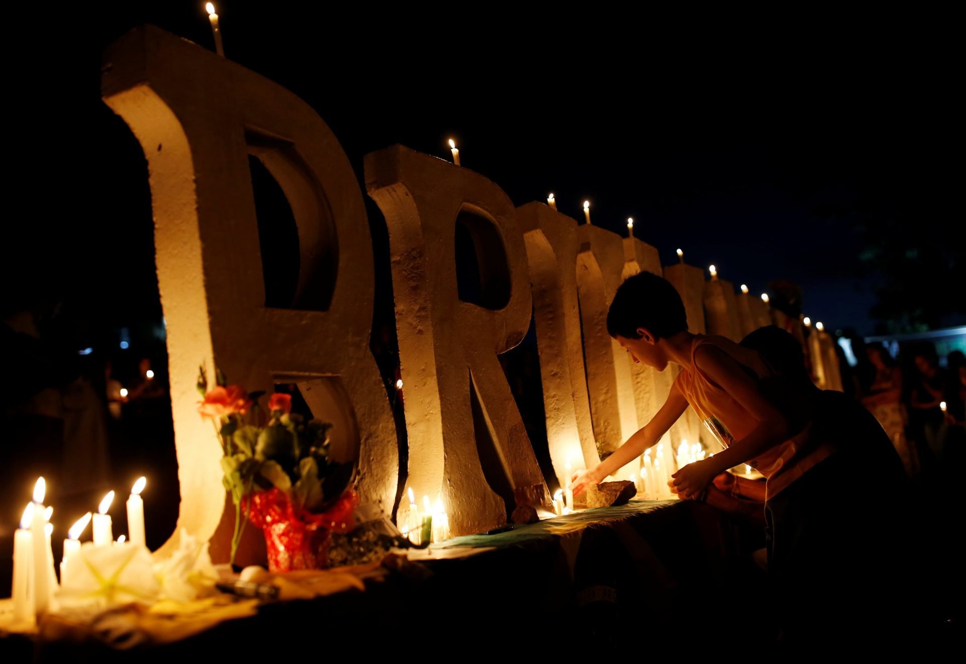 People light candles during a vigil following the Vale dam burst in Brazil